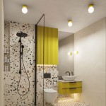 Kinkiet Zori 1xG9 w kolorze żółtym, zamontowany na ścianie w łazience. Okrągła lampa z widocznym źródłem światła, otoczona prostą oprawą. W tle znajdują się elementy dekoracyjne w odcieniach beżu i terakoty.