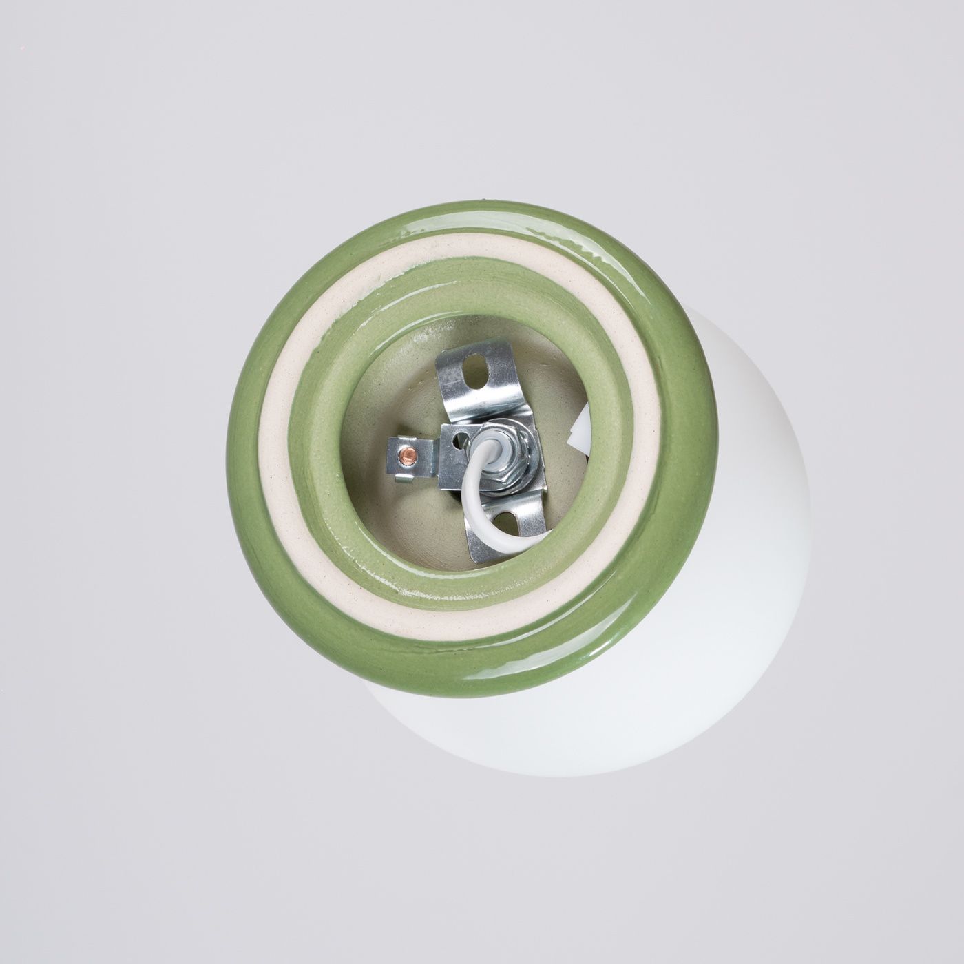 Kinkiet Zori 1xG9 IP44 w kolorze zielonym z ceramicznym kloszem. Widok z dołu, ukazujący metalowy uchwyt i miejsca montażowe. Gładka, matowa faktura z wyraźnym, zielonym obrzeżem.