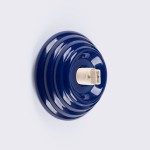 Kinkiet Zori 1xG9 w kolorze ultramaryny, z okrągłą, teksturowaną podstawą. Widoczny gwint na żarówkę G9. Produkt montowany na ścianie, na jednolitym tle. Wysoka odporność na wilgoć (IP44).