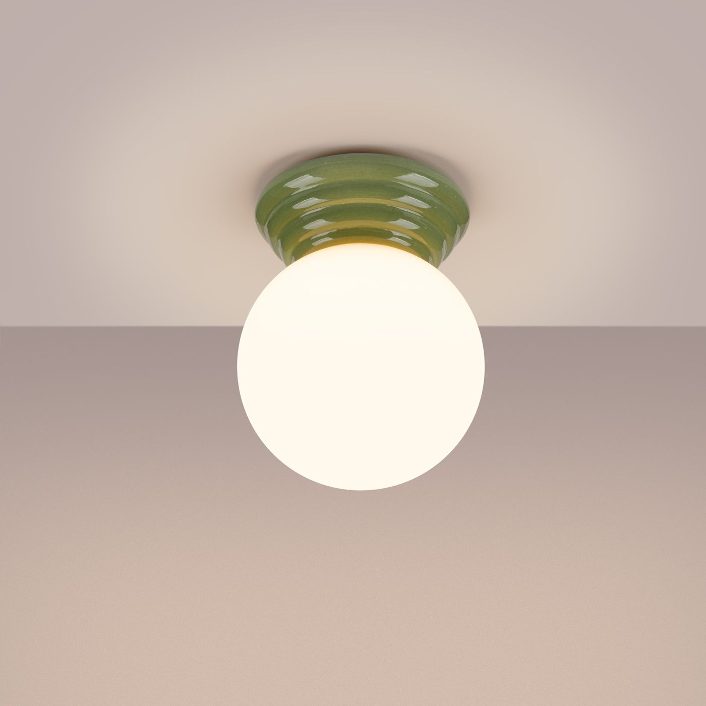 Lampa sufitowa Zori z zielonym, teksturowanym kloszem i okrągłym, białym źródłem światła. Ujęcie z dołu, lampa zamontowana na suficie, na jasnym tle. Idealna do oświetlenia wnętrz, klasa IP44 zapewnia odporność na wilgoć.