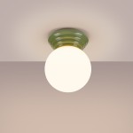 Lampa sufitowa Zori z zielonym, teksturowanym kloszem i okrągłym, białym źródłem światła. Ujęcie z dołu, lampa zamontowana na suficie, na jasnym tle. Idealna do oświetlenia wnętrz, klasa IP44 zapewnia odporność na wilgoć.
