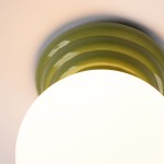 Zori lampa sufitowa 1xG9 IP44 w kolorze zielonym, z okrągłym, białym kloszem oraz dekoracyjnym, falistym zielonym mocowaniem. Ujęcie z boku, pokazujące detal górnej części lampy. Idealna do łazienek lub przestrzeni o wysokiej wilgotności.