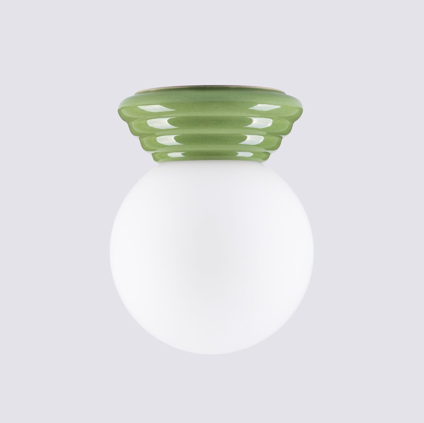 Lampa sufitowa Zori w kolorze zielonym z ceramiczną, falistą podstawą oraz okrągłym, matowym kloszem z białego szkła. Ujęcie frontalne, produkt zamontowany na suficie. Idealna do wnętrz, zapewniająca stylowe oświetlenie.