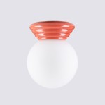 Brzoskwiniowa lampa sufitowa Zori z oprawą w kształcie okrągłej główki i falistego klosza. Wyposażona w gniazdo 1xG9, charakteryzuje się matową białą kulą i gładkim, połyskującym wykończeniem. Ujęcie frontalne, na jednolitym tle.