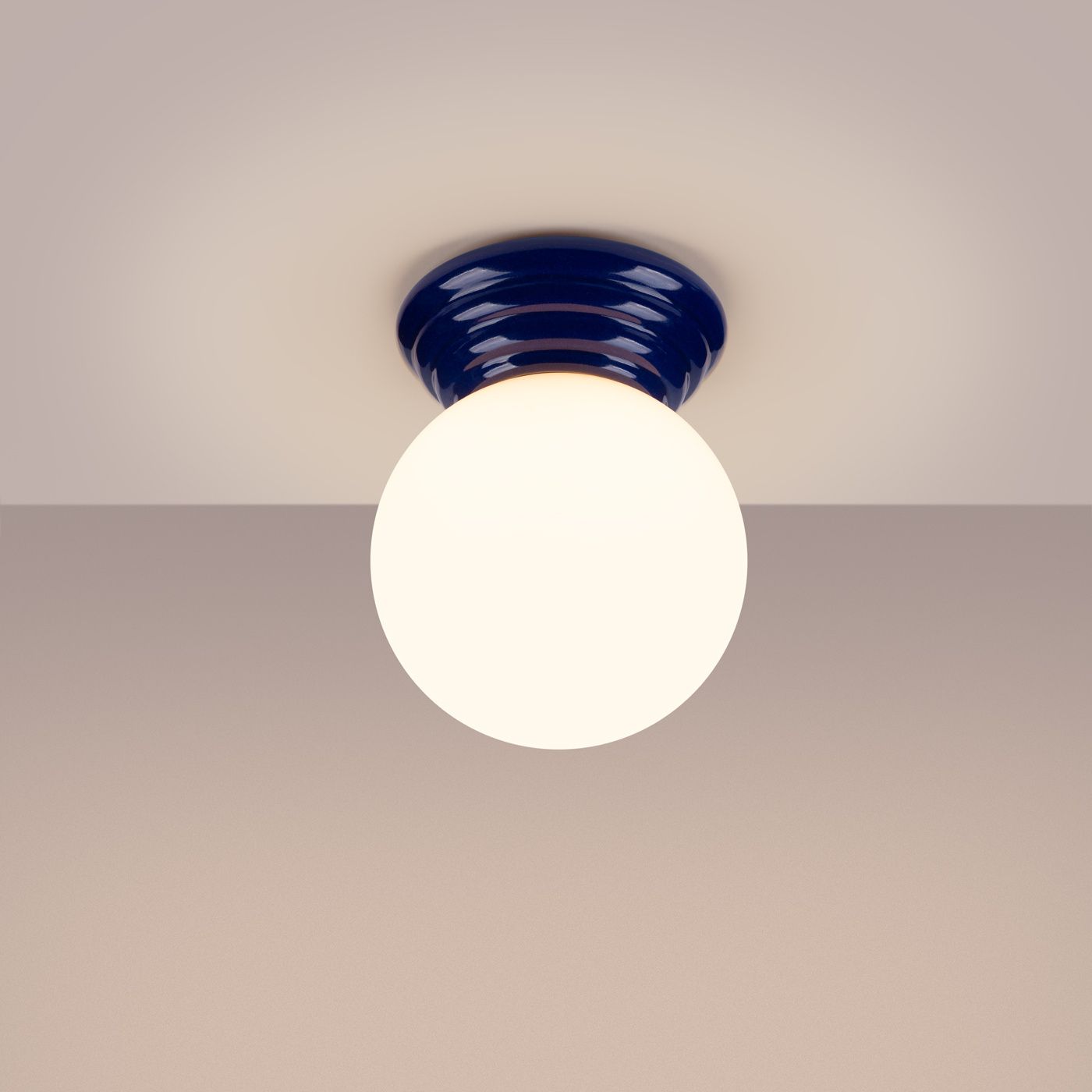 Lampa sufitowa Zori w kolorze ultramaryny z okrągłą, białą kloszem. Ujęcie frontalne, zamontowana na suficie. Wysoka odporność na wilgoć (IP44), idealna do łazienek lub innych wilgotnych pomieszczeń.