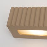Kinkiet Rigata 1xE27 w kolorze taupe z falistą fakturą. Produkt w formie prostokątnej, z wycięciem na źródło światła, podkreślający nowoczesny design. Ujęcie z góry, na jednolitym tle.