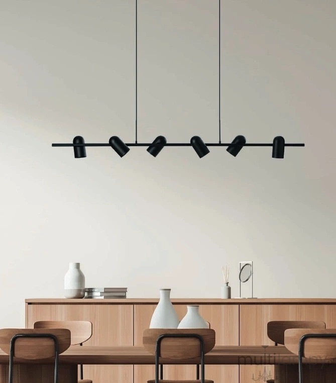 Lampa wisząca Vivi w kolorze czarnym, z sześcioma punktami świetlnymi GU10. Ujęcie frontalne, zawieszona nad drewnianym stołem, na tle jasnej ściany. W widoku widać również dekoracyjne wazony i książki na komodzie.