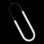 Czarna lampa wisząca LED 9W Nexus AZ5739 o kształcie zbliżonym do klipsa, z białymi elementami świecącymi. Zawieszona na cienkim przewodzie, prezentuje nowoczesny design na jednolitym, czarnym tle.