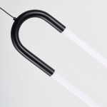 Lampa wisząca LED Nexus 9W w kolorze czarnym, o minimalistycznym kształcie z zaokrąglonym uchwytem. Widoczne elementy to czarna metalowa oprawa oraz przezroczyste, liniowe źródło światła. Produkt zawieszony na cienkim przewodzie, na jasnym tle.
