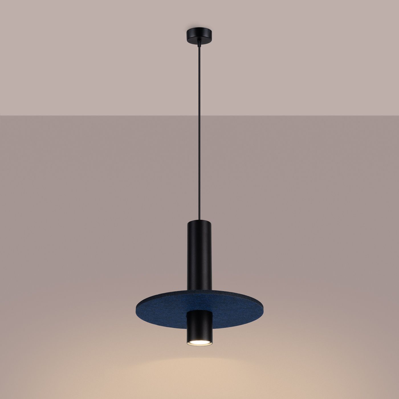 Lampa wisząca Pelta w kolorze czarnym i granatowym, z okrągłym kloszem i cylindrycznym korpusem. Zawieszona na cienkim przewodzie, z widocznym źródłem światła GU10. Kąt ujęcia frontalny, na jednolitym tle.