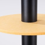 Lampa wisząca Pelta z czarnym metalowym stelażem i żółtą okrągłą podstawą. Widoczny detal łączenia elementów oraz tekstura żółtej powierzchni. Ujęcie z boku, ukazujące prostą formę i kontrast kolorystyczny.