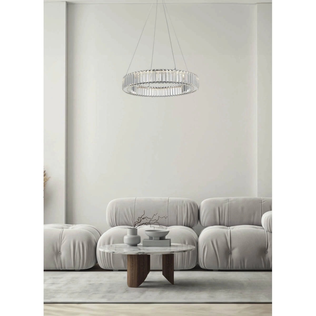 Lampa wisząca LED Spark D60 30W w chromowanej obudowie, o okrągłym kształcie, zawieszona na cienkich linkach. Widoczna w nowoczesnym wnętrzu z beżowymi sofami i okrągłym stołem. Oświetlenie z kryształowymi detalami.