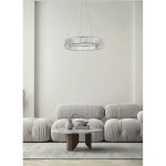 Lampa wisząca LED Spark D60 30W w chromowanej obudowie, o okrągłym kształcie, zawieszona na cienkich linkach. Widoczna w nowoczesnym wnętrzu z beżowymi sofami i okrągłym stołem. Oświetlenie z kryształowymi detalami.