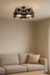 Lampa sufitowa Malavi w kolorze czarnym, z pięcioma oprawami E27. Okrągłe klosze z siatki metalowej, umieszczone w dwóch poziomach. Montowana na suficie, w nowoczesnym wnętrzu, obok beżowej sofy.
