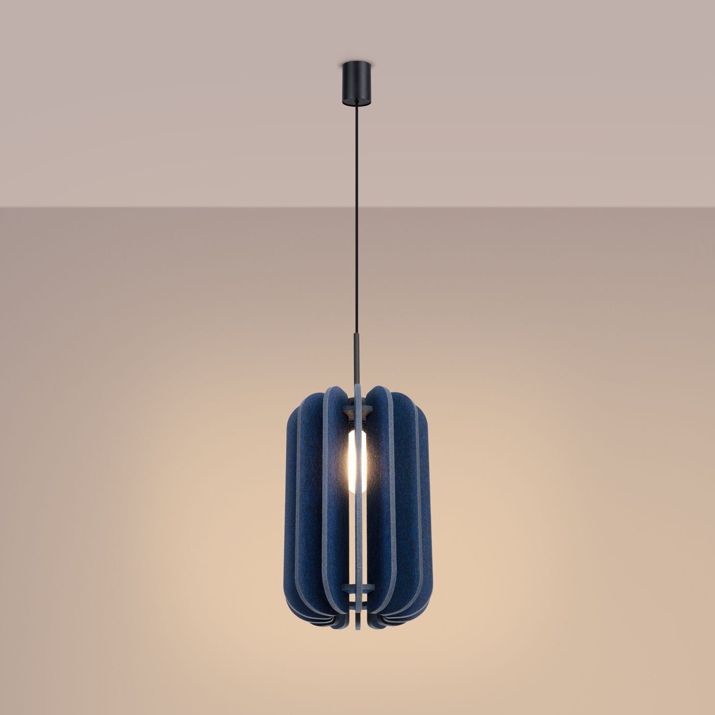 Lampa wisząca Mula D27 w kolorze czarnym i granatowym, z kloszem o owalnym kształcie, wykonanym z materiału tekstylnego. Zawieszona na cienkim, czarnym kablu. Widoczna żarówka E27 w centralnej części lampy. Tło jasne, jednolite.