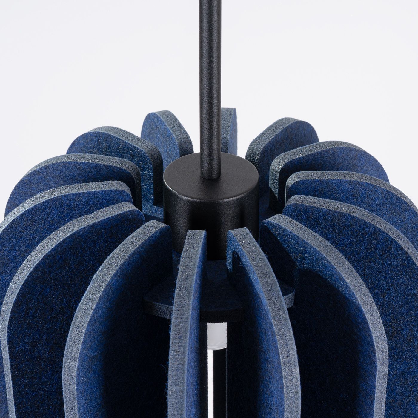 Lampa wisząca Mula D27 z materiału filcowego w kolorze granatowym i czarnym, o okrągłym kształcie. Widoczny metalowy uchwyt z czarnym wykończeniem. Kąt ujęcia zbliżony na detal struktury materiału.