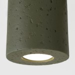 Lampa sufitowa Orbis Beton w kolorze oliwkowej zieleni, wykonana z teksturowanego betonu. Cylindryczny kształt z widocznym otworem na żarówkę GU10, zawieszona w pozycji pionowej. Tło proste, białe.
