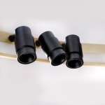 Lampa sufitowa Serafino D82 z siedmioma oprawami LED. Oprawy w kolorze czarnym, zamocowane na złotej listwie. Ujęcie z boku, pokazujące detale opraw i ich kształt cylindryczny. Tło neutralne, podkreślające design lampy.