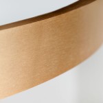 Złota obręcz lampy sufitowej Serafino D82, wykonana z matowego metalu, z widoczną teksturą. Obręcz lekko zakrzywiona, z białym wnętrzem. Lampa przeznaczona do montażu sufitowego, z miejscem na 7 źródeł LED. Tło jasne, neutralne.