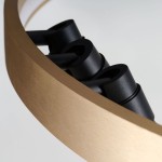 Lampa wisząca Serafino D60 z siedmioma żarówkami LED, w kolorze złotym i czarnym. Ujęcie z bliska pokazuje czarne oprawy LED umieszczone na złotej, matowej ramie. Kształt okrągły, minimalistyczny design.