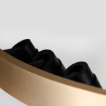 Lampa wisząca Serafino D60 z siedmioma źródłami LED, w kolorze złotym i czarnym. Widoczne czarne elementy w kształcie cylindrów oraz złota, matowa obręcz. Ujęcie z boku, ukazujące detale konstrukcji.