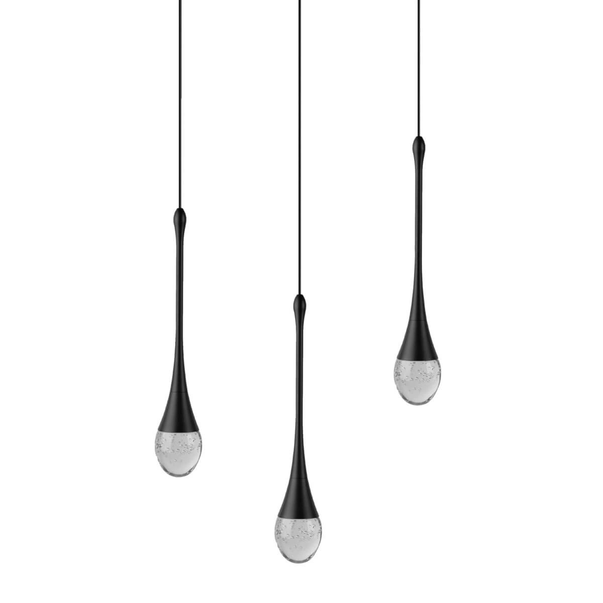 Lampa wisząca Dalma z trzema źródłami światła LED 28W w kolorze czarnym. Kształt kropli z przezroczystym, zdobionym kloszem. Zawieszona na cienkich linkach, w nowoczesnym stylu. Idealna do wnętrz minimalistycznych.