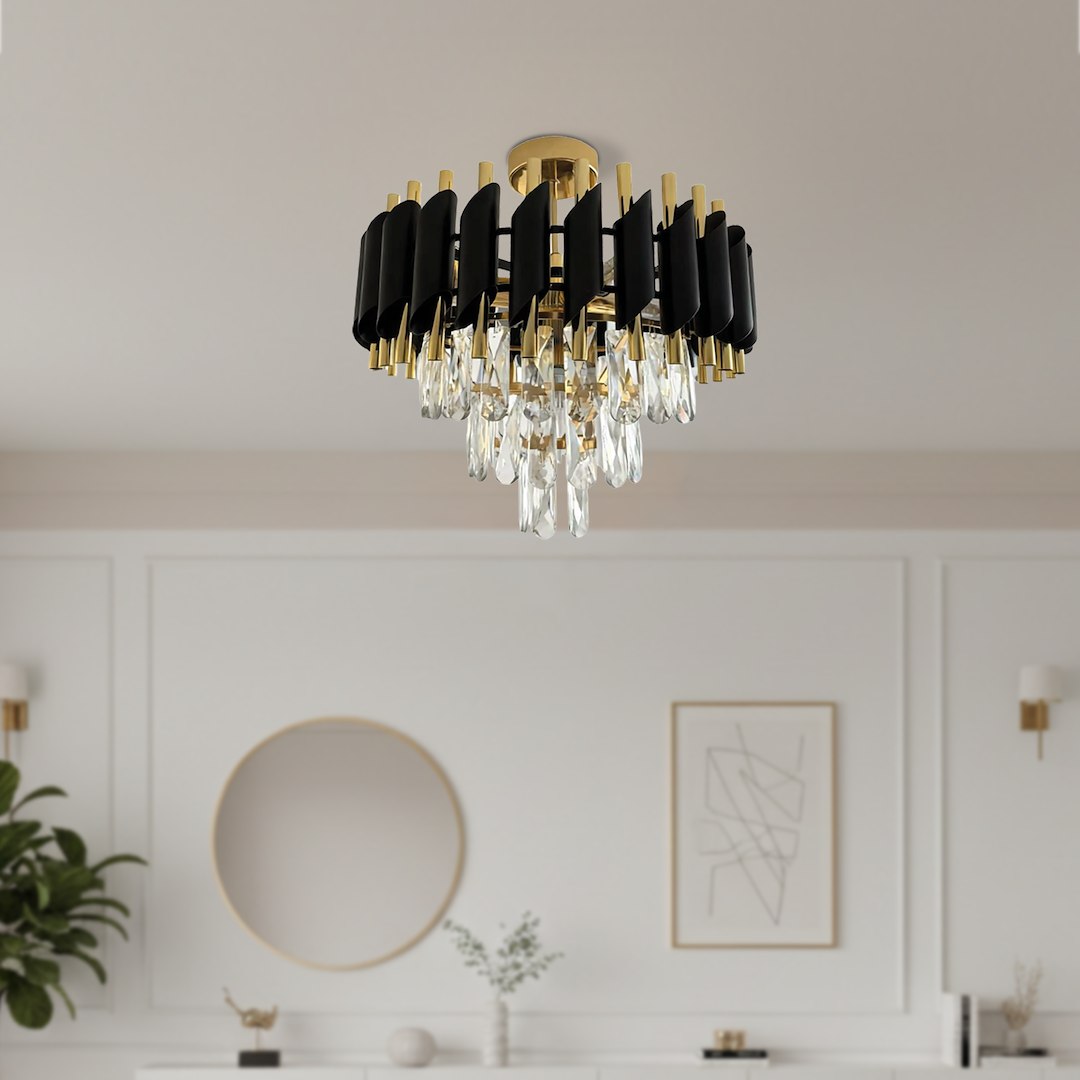 Lampa sufitowa Cristal z pięcioma oprawami E14, w kolorze złotym, z czarnymi elementami i kryształowymi zwisami. Umieszczona na suficie, prezentuje nowoczesny design w eleganckim stylu, w otoczeniu jasnego wnętrza.