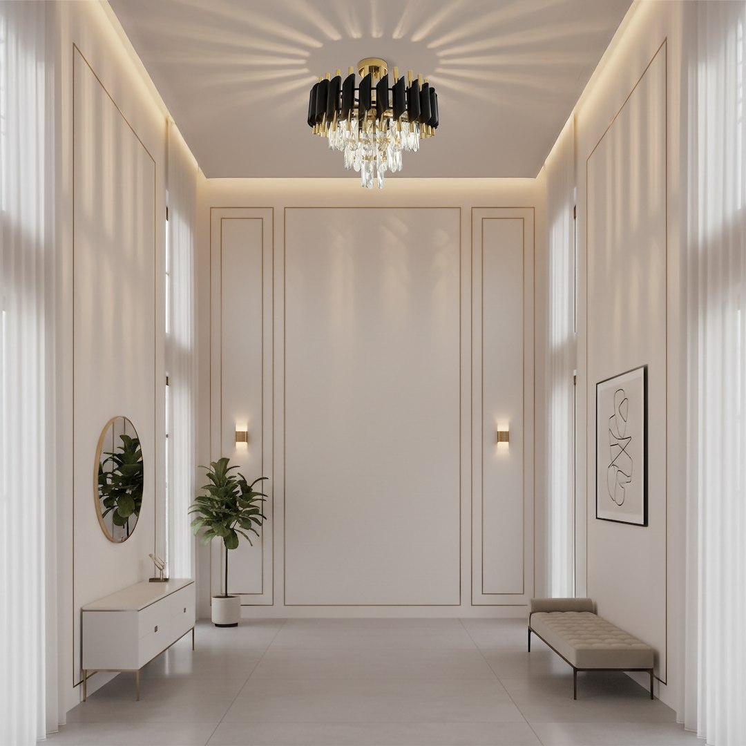 Lampa sufitowa Cristal 5xE14 w kolorze złotym, z ozdobnymi kryształami, umieszczona centralnie w eleganckim wnętrzu. Kształt okrągły, z czarnymi elementami, rzucająca efektowne cienie na sufit. W tle widoczna roślina i minimalistyczne meble.