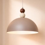 Lampa wisząca Bento 1xE27 w kolorze kaszmiru, z matową, półkulistą osłoną i dekoracyjnymi kulkami w odcieniach brązu i bieli. Zawieszona na cienkim przewodzie, idealna do nowoczesnych wnętrz.