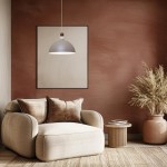 Lampa wisząca Bento w kolorze kaszmiru z kloszem w kształcie półkuli, zawieszona na cienkim przewodzie. W tle widoczna ściana w odcieniu terakoty oraz wygodny fotel w jasnym materiale z poduszkami.
