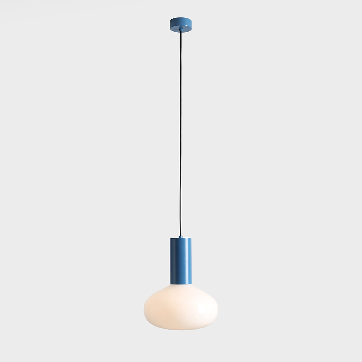 Lampa wisząca Flo Sky D26 z oprawą w kolorze niebieskim i białym kloszem w kształcie kuli. Montowana na długim, czarnym przewodzie. Przeznaczona do żarówki E14, wisząca w centralnym ujęciu na jasnym tle.