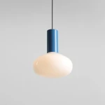 Lampa wisząca Flo Sky D26 z opalowym kloszem w kształcie kuli i metalowym niebieskim trzonem, zawieszona na czarnym przewodzie. Klosz ma gładką fakturę, a całość prezentuje nowoczesny design.