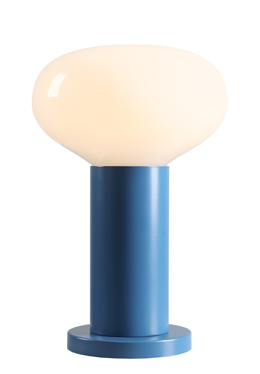 Duża lampa stołowa Flo Sky z niebieską podstawą i matowym kloszem w kształcie owalu. Produkt stoi na okrągłej podstawie, z widocznym uchwytem E14. Tło białe, co podkreśla kolor lampy.