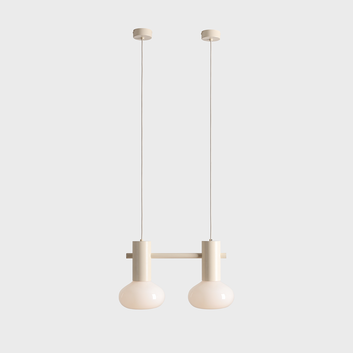Lampa wisząca Flo Cream z dwoma kulistymi kloszami w kolorze kremowym, zawieszona na cienkich linkach. Metalowa podstawa w tym samym odcieniu. Całość na gładkim, jasnym tle, co podkreśla nowoczesny design lampy.