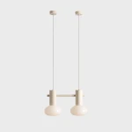 Lampa wisząca Flo Cream z dwoma kulistymi kloszami w kolorze kremowym, zawieszona na cienkich linkach. Metalowa podstawa w tym samym odcieniu. Całość na gładkim, jasnym tle, co podkreśla nowoczesny design lampy.