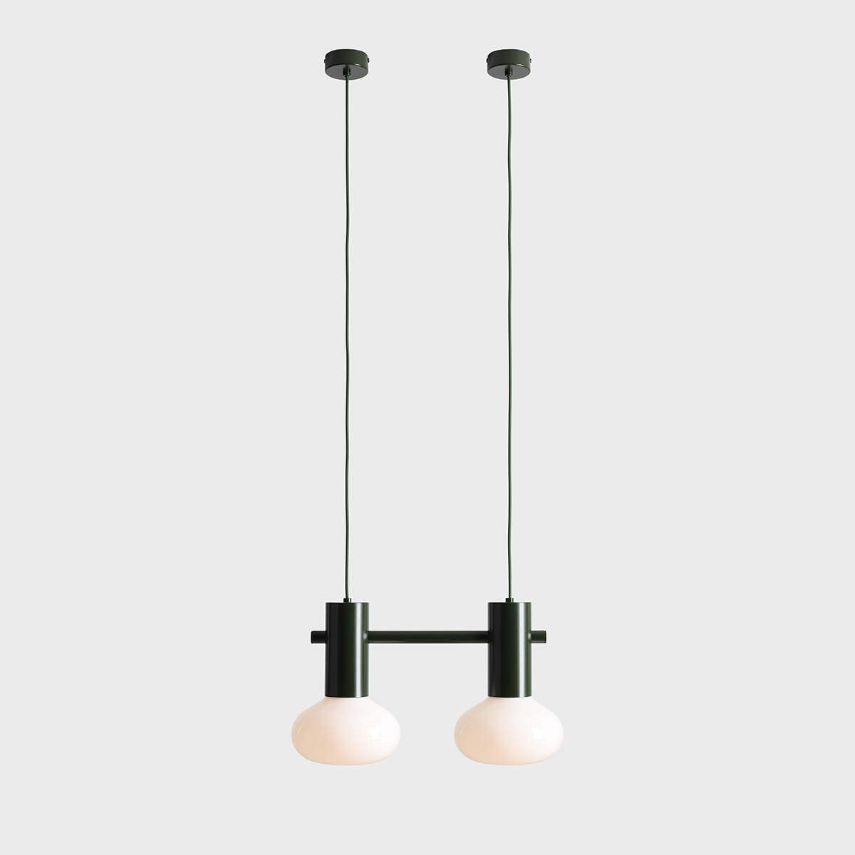 Lampa wisząca Flo Moss z dwoma oprawami E14, z ciemnozielonym metalowym stelażem i mlecznymi, okrągłymi kloszami. Ułożona w pionie, na długich przewodach, w minimalistycznym stylu, na jednolitym tle.