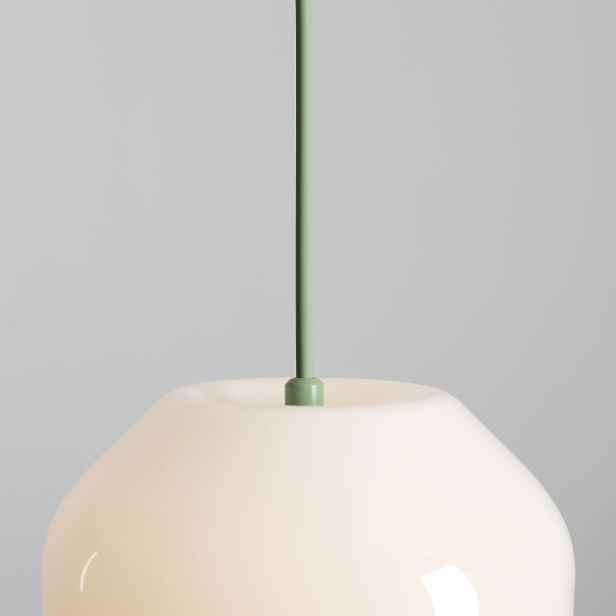 Lampa wisząca Flask Sage D18 z kloszem w kolorze białym i zielonym zawieszeniem. Kształt klosza jest zaokrąglony, z delikatnym wykończeniem. Produkt montowany na suficie, idealny do nowoczesnych wnętrz.