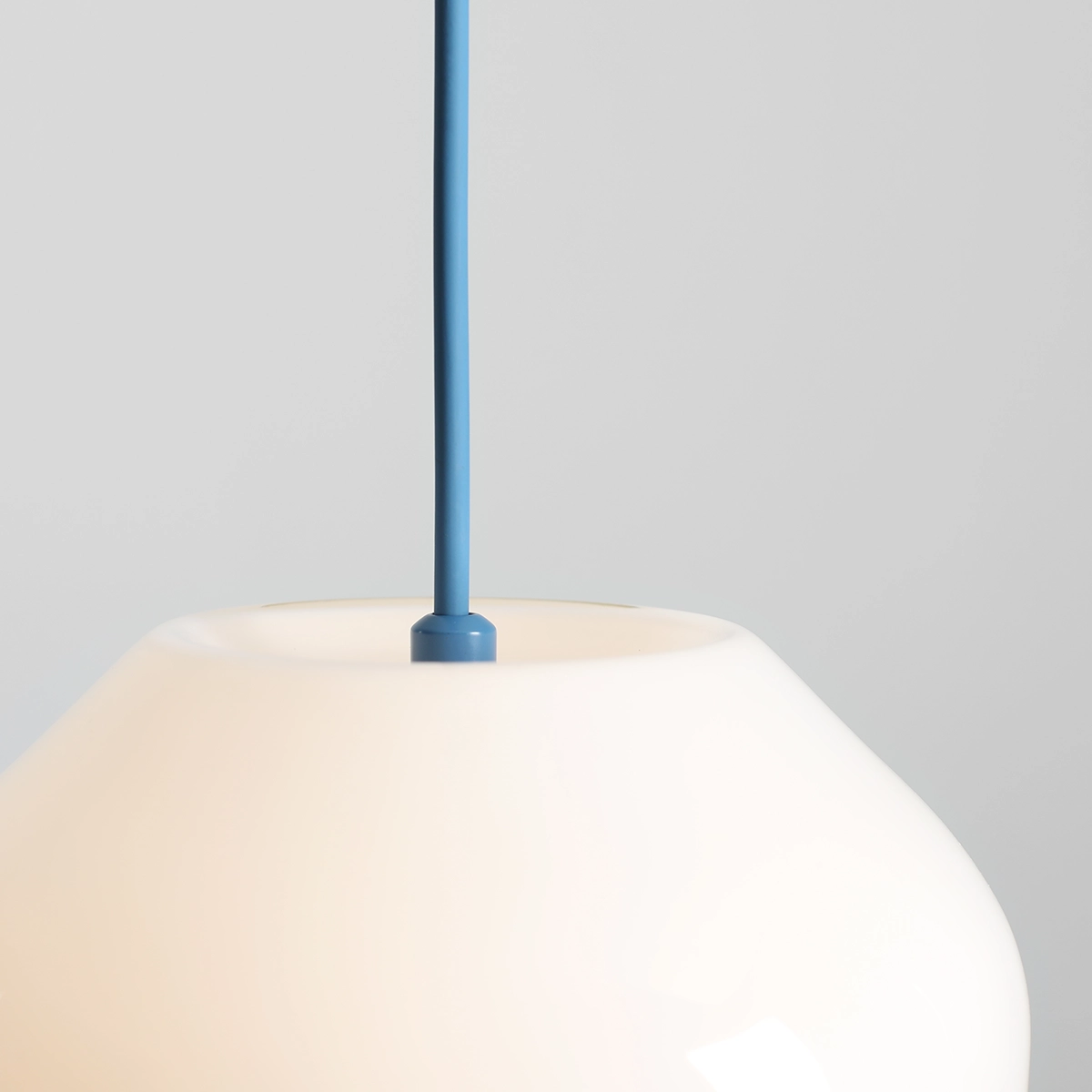Lampa wisząca Flask Sapphire D18 z niebieskim kablem i białym kloszem o miękkim kształcie. Widoczny górny detal mocowania. Produkt w zbliżeniu, na jednolitym tle. Idealna do nowoczesnych wnętrz.