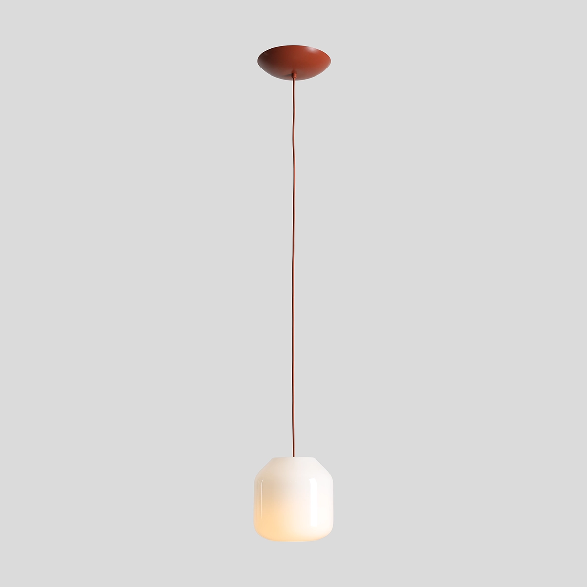 Lampa wisząca Flask Terra D18 z kloszem w kształcie sześcianu, wykonana z białego szkła, zawieszona na ceglanej oprawie. Długa, gładka linka w kolorze ceglastym. Klosz emitujący ciepłe światło, montowany na suficie.