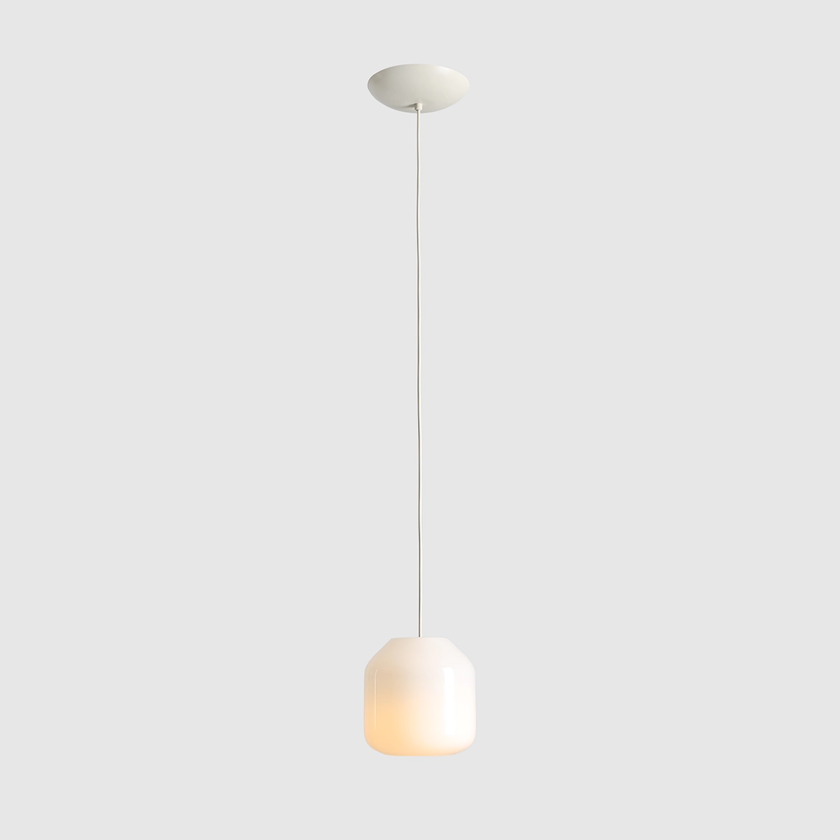 Kremowa lampa wisząca Flask Cotton D18 z kloszem w kształcie prostopadłościanu, zawieszona na cienkim, białym kablu. Źródło światła E14. Tło w jednolitym, jasnoszarym kolorze.