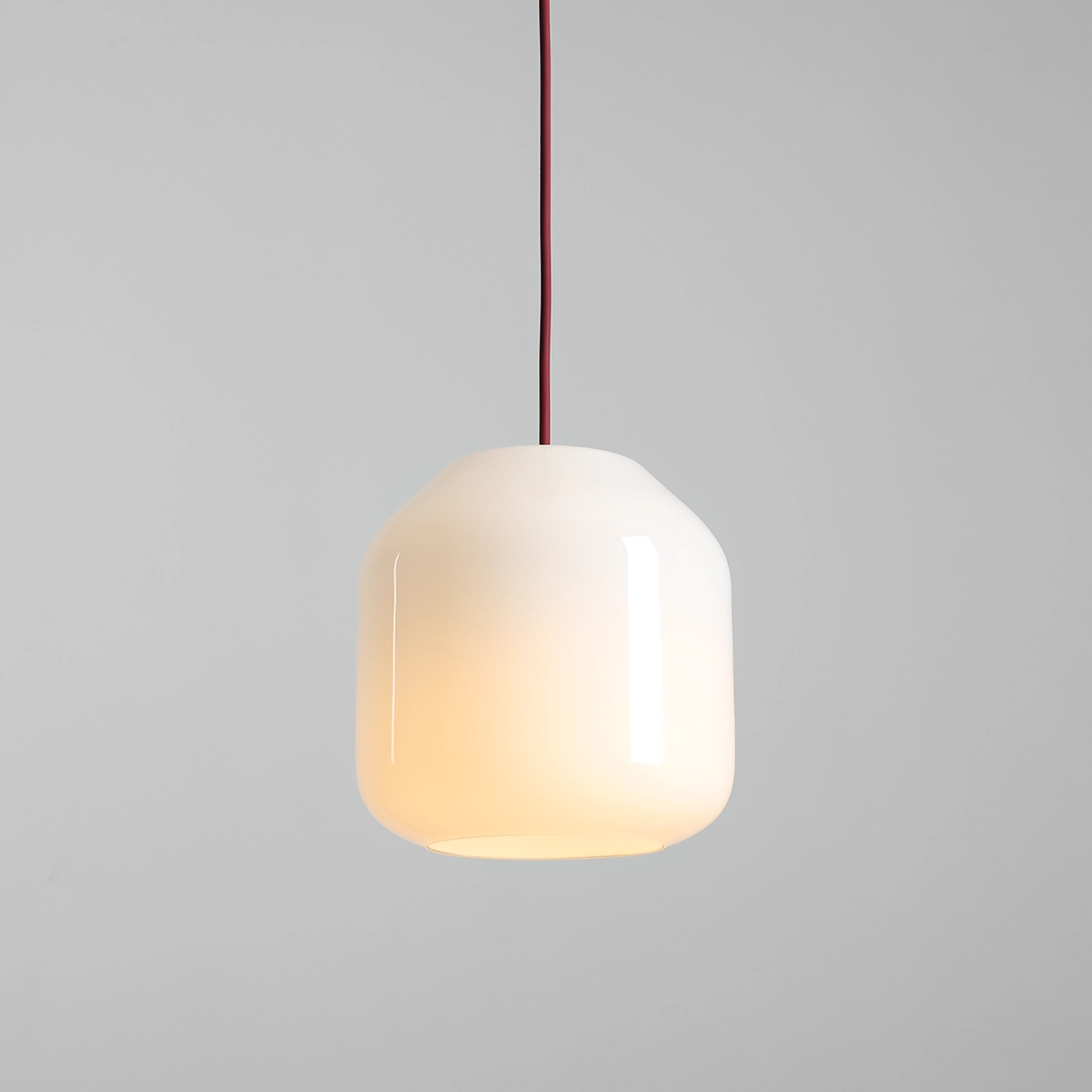 Lampa wisząca Flask Cherry D18 z białym, półprzezroczystym kloszem w kształcie słoika, zawieszona na bordowym przewodzie. Klosz ma gładką powierzchnię, a lampa jest przystosowana do żarówki E14. Tło jest szare, co podkreśla elegancję lampy.