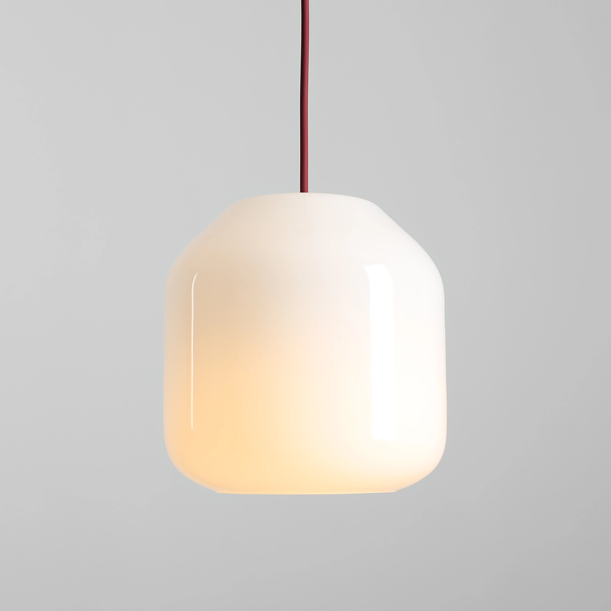 Lampa wisząca Flask Cherry D18 z kloszem w kształcie prostopadłościanu, wykonana z białego szkła, zawieszona na bordowym przewodzie. Źródło światła E14, umieszczona na jednolitym szarym tle.