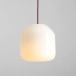 Lampa wisząca Flask Cherry D18 z kloszem w kształcie prostopadłościanu, wykonana z białego szkła, zawieszona na bordowym przewodzie. Źródło światła E14, umieszczona na jednolitym szarym tle.