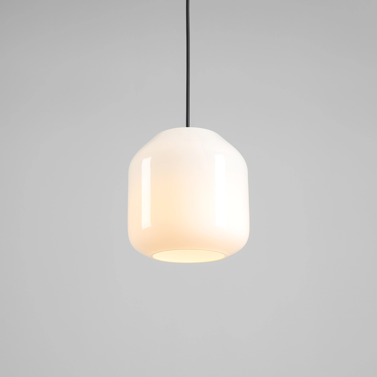 Lampa wisząca Flask Orchid D18 z oprawą w kształcie szklanej, białej lampy z czarnym przewodem. Gładka, zaokrąglona forma, zawieszona na prostym, czarnym kabelku, wyróżnia się minimalistycznym designem.