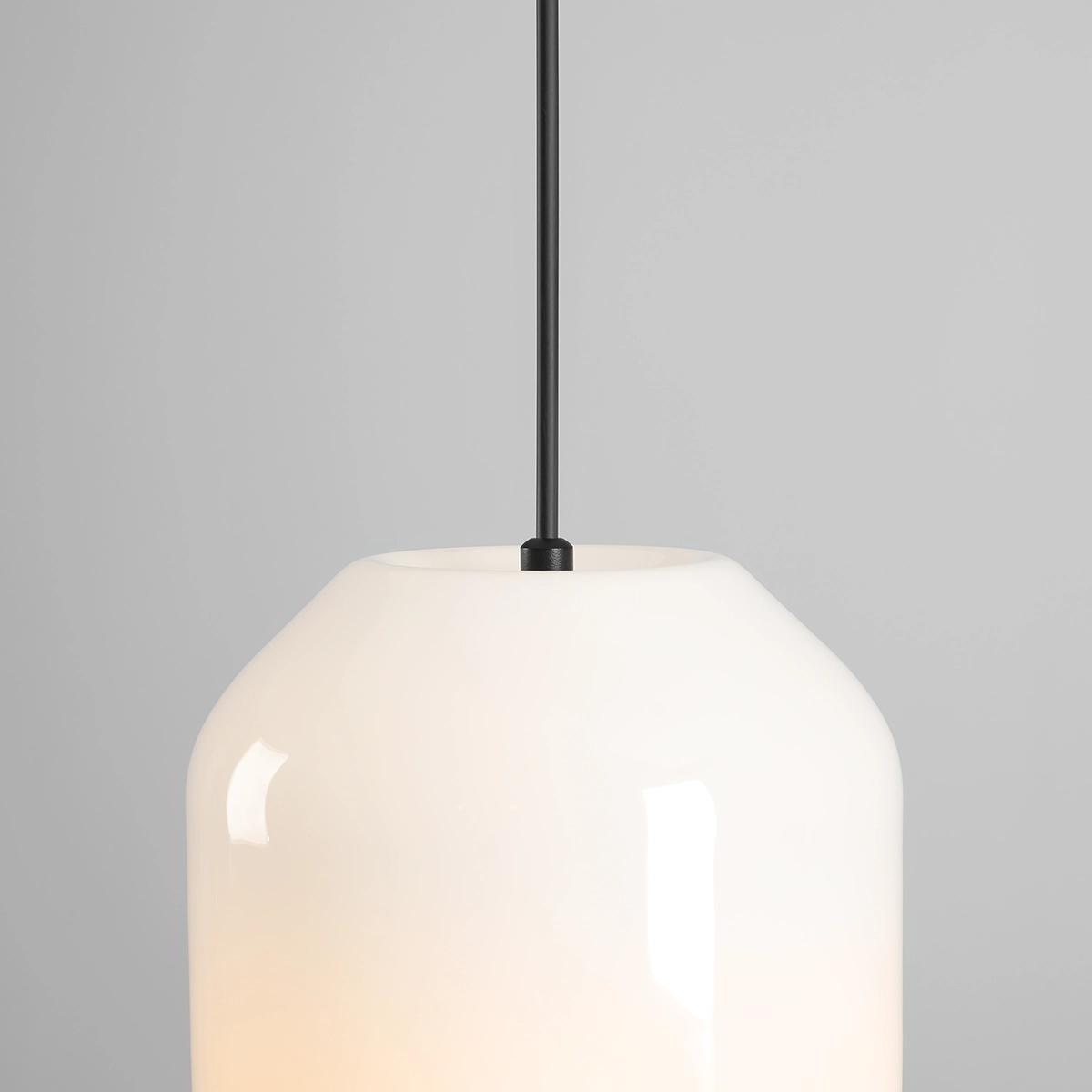 Lampa wisząca Flask Orchid D18 z kloszem w kształcie jajka, wykonanym z białego szkła, zawieszona na cienkim, czarnym przewodzie. Widoczny detal mocowania u góry. Klosz ma gładką, błyszczącą powierzchnię. Tło szare.