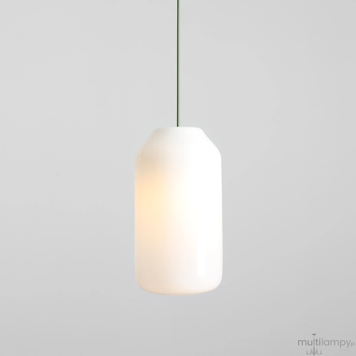 Lampa wisząca Flask Sage D19 z kloszem w kolorze białym i cienkim, zielonym przewodem. Kształt cylindryczny, delikatna faktura. Oświetlenie włączone, emitujące ciepłe światło. Prosta aranżacja na jednolitym tle.