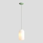 Lampa wisząca Flask Sage D19 z kloszem w kolorze białym, o delikatnie zaokrąglonym kształcie, zawieszona na cienkim zielonym kablu. Montowana do sufitu, emituje ciepłe światło, idealna do nowoczesnych wnętrz.