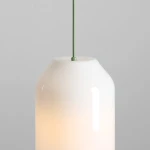 Lampa wisząca Flask Sage D19 z jednym gniazdem E27. Klosz w kształcie butelki wykonany z białego szkła, z matowym wykończeniem i zielonym przewodem. Wisi w pionie, na jednolitym tle.