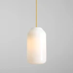 Lampa wisząca Flask Mimosa D19 z kloszem w białym kolorze i żółtym przewodem. Okrągły kształt, jedno źródło światła E27. Zawieszona w pionie na jasnym tle, subtelne oświetlenie.