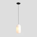 Lampa wisząca Flask Orchid D19 w kolorze czarnym, z białym kloszem w kształcie prostokątnym. Zawieszona na cienkim kablu, z mocowaniem sufitowym. Źródło światła E27. Tło w jasnoszarym odcieniu.